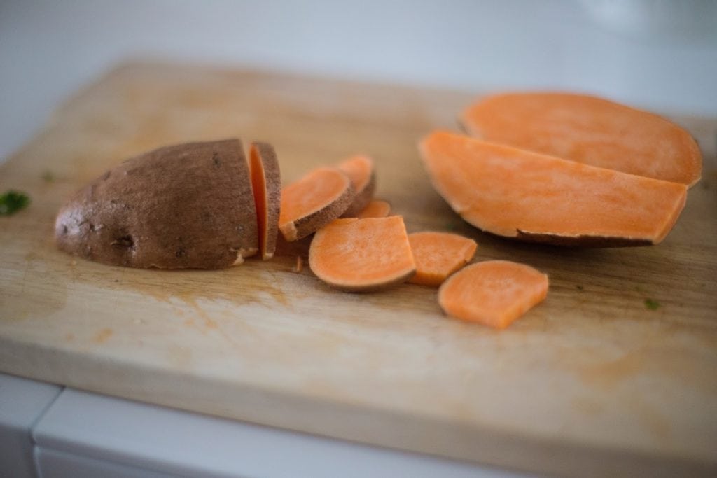 Cutting board with a sweet potato on it