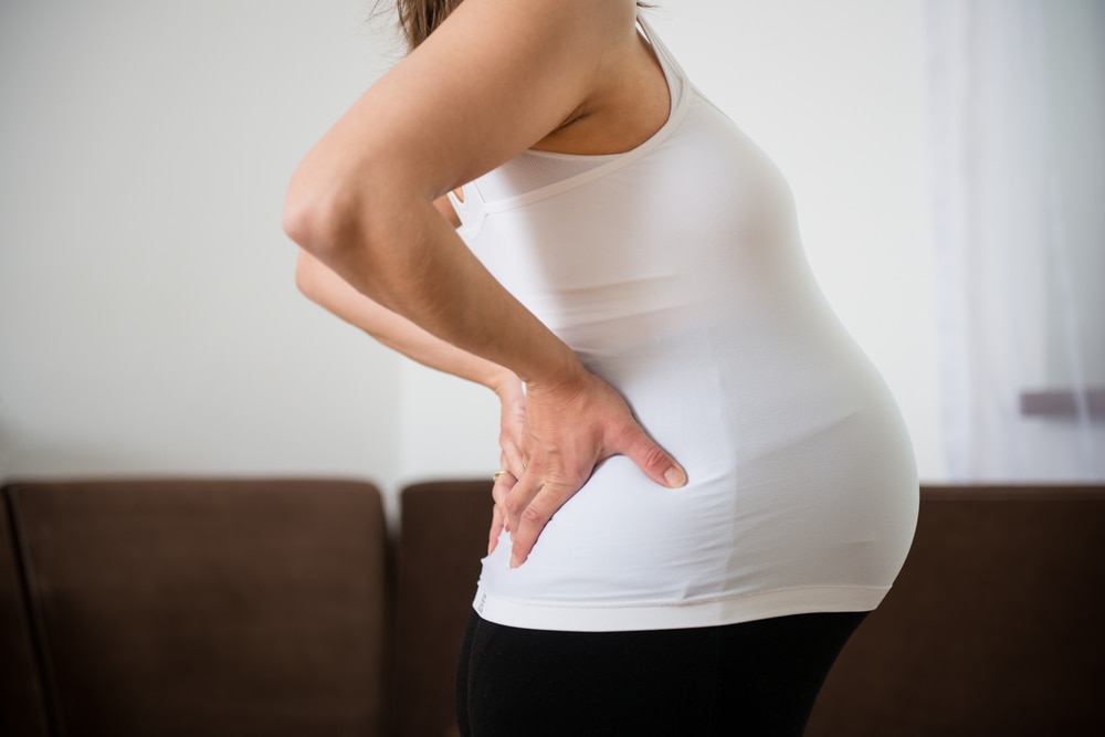 Pregnant woman holding her back in pain