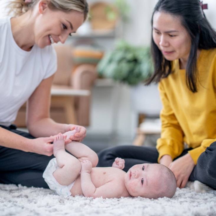 Mother holding newborn receiving postpartum physiotherapy