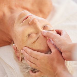 Relax, head massage and senior woman at a spa for luxury, self care and muscle healing treatment. Health, wellness and elderly female person on a retirement retreat for body therapy at natural salon.